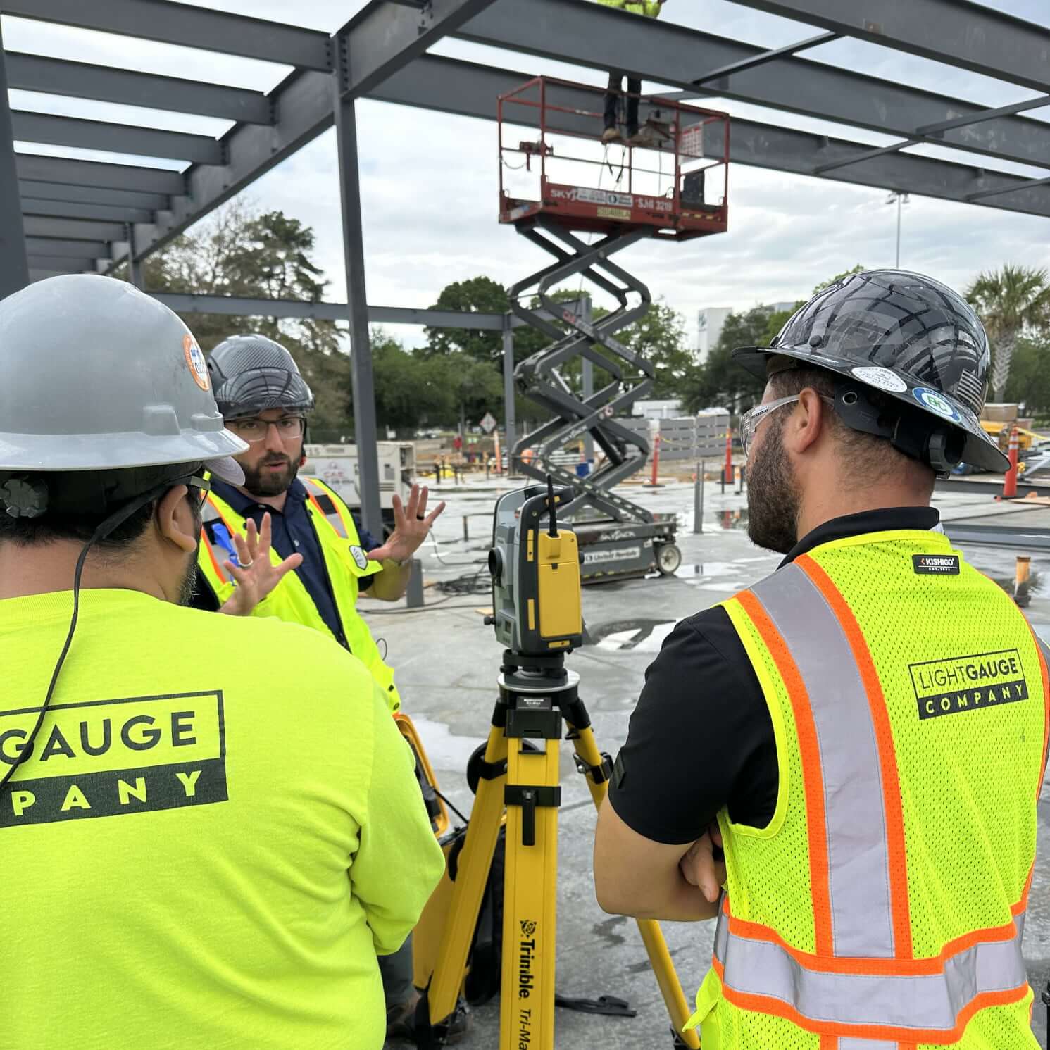 three lightgauge co workers discussing the construction projecr while they are on site